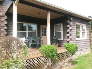 Log cabin porch with topiary plants finished in Timberline Gray