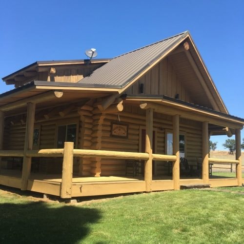 Rustic log cabin with front porch finished in Natural Pine Special