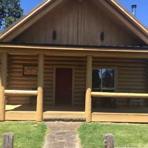 Rustic log cabin with front porch finished in Natural Pine Special