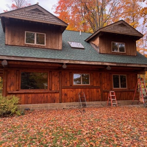 Rustic wooden house with autumn foliage finished in Men-Wood Coatings